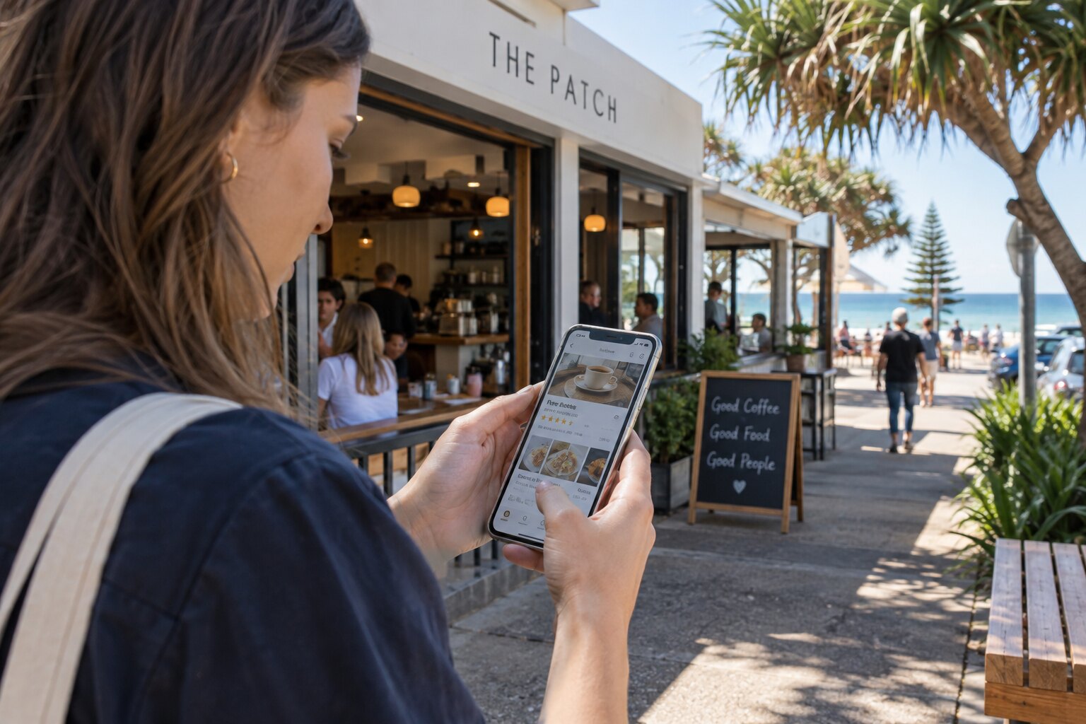 Customer checking a local business listing outside a coastal cafe